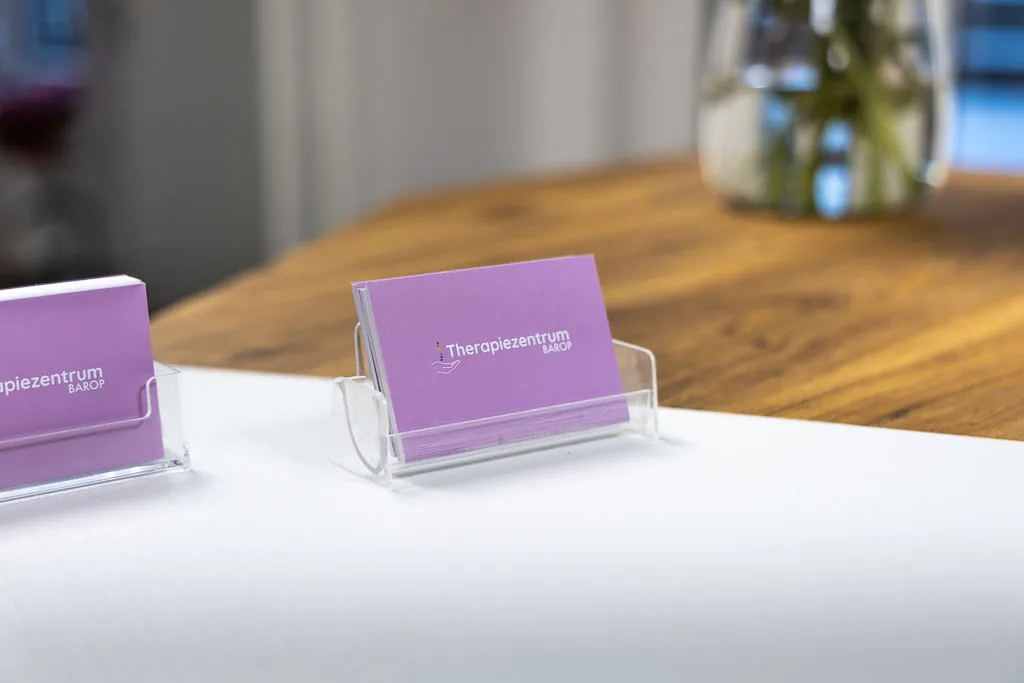 Visitenkarten des Therapiezentrums Barop auf einem Holztisch